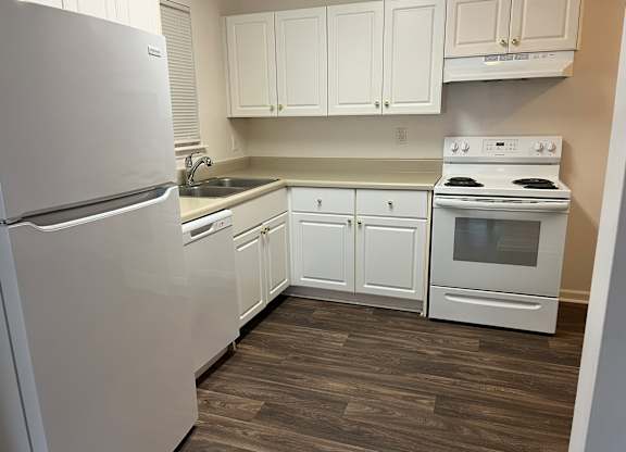A kitchen with white appliances and cabinets.