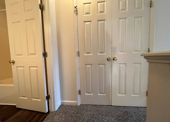 A hallway with white doors and a carpeted floor.