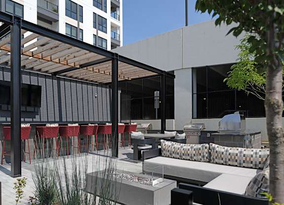 a patio with tables and chairs and a grill