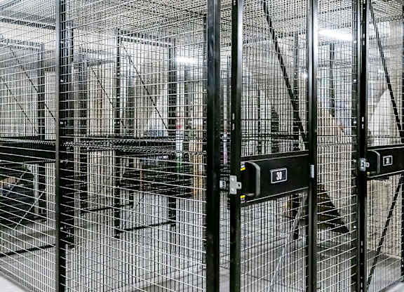 a group of cages in a building with doors