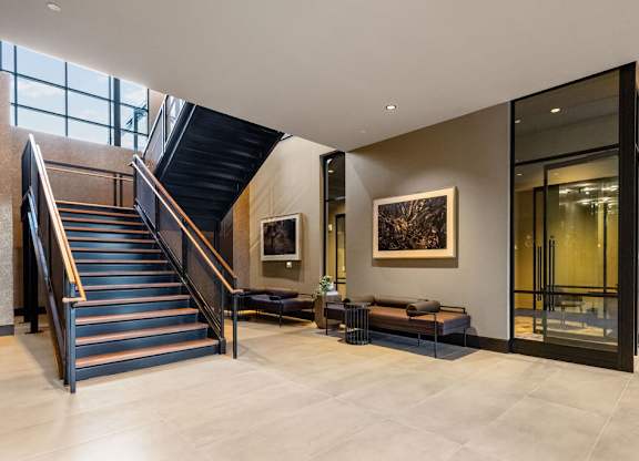 a staircase in the lobby of a building with a glass door