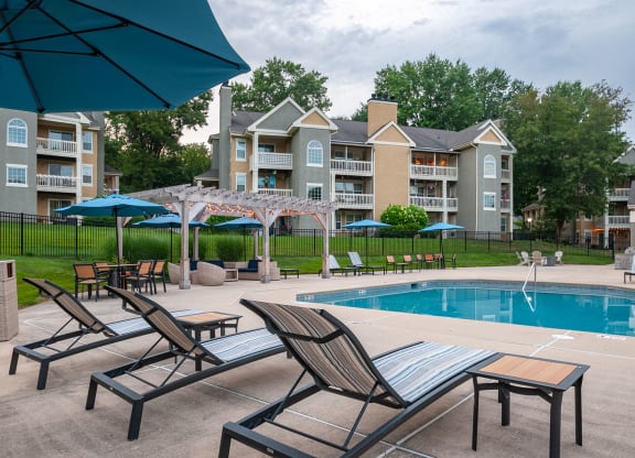 Lounge chairs at the pool looking out toward cabana and apartment building in the distance at Madison Glen Mills, Pennsylvania, 19342