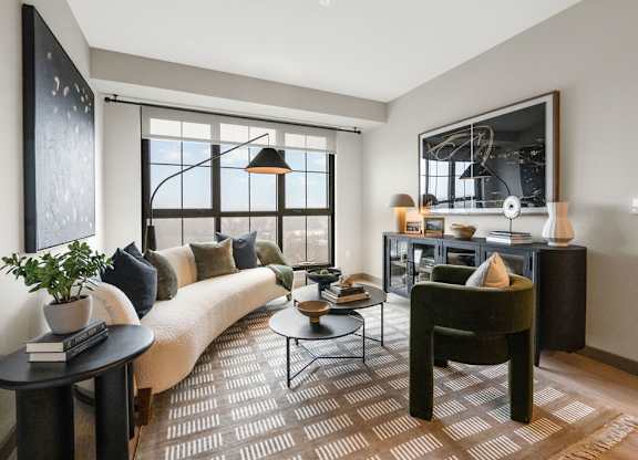 a living room with a couch and a chair in front of a window