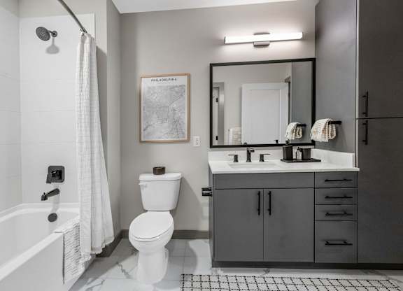 a bathroom with a toilet sink and shower and a mirror