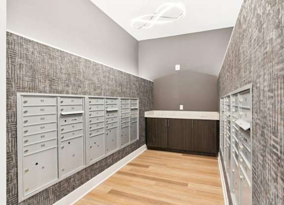 A hallway with a row of mailboxes on the wall.