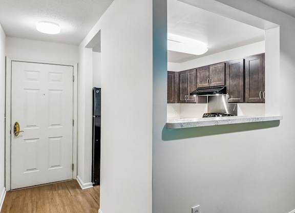 A white door with a gold handle is in a hallway.