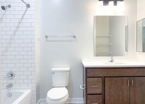 A white toilet sits next to a white sink in a bathroom.