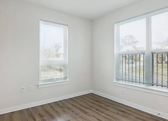 A room with a window and a wooden floor.