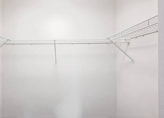 A white wall with a metal rack on it.