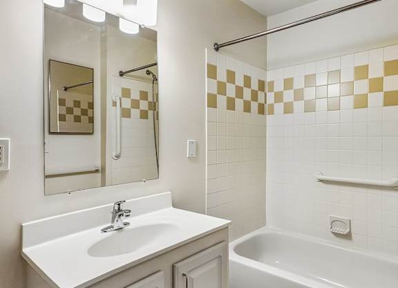 A bathroom with a white sink and a white bathtub.