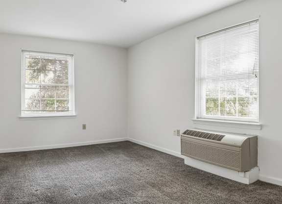 A room with a window and a wall-mounted air conditioner.