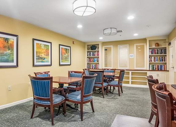 A room with a table and chairs and a bookcase.