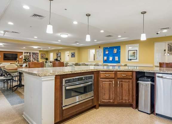A kitchen with a white island and wooden cabinets.