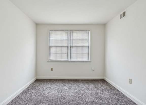 Carpeted bedroom in Park View at Towson with two windows and closet space