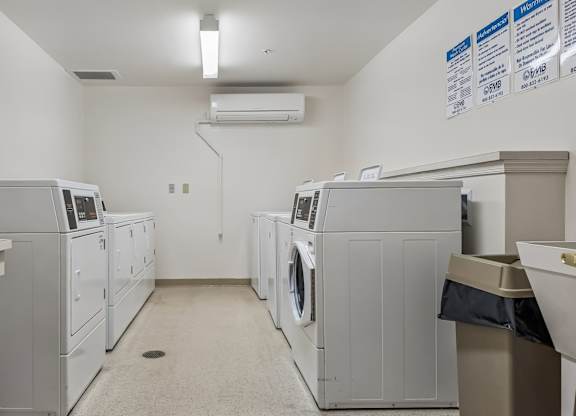 A laundry room with washers and dryers.