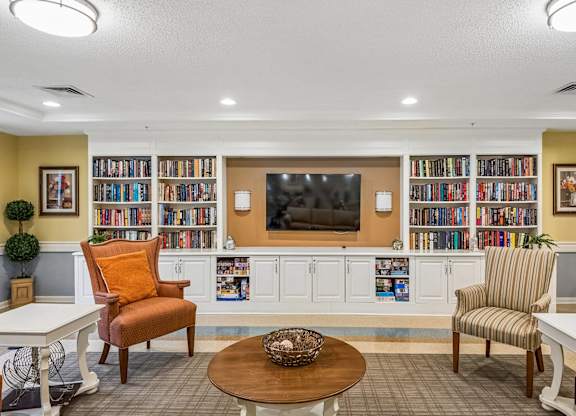 A living room with a television, two chairs, a sofa, and a coffee table.