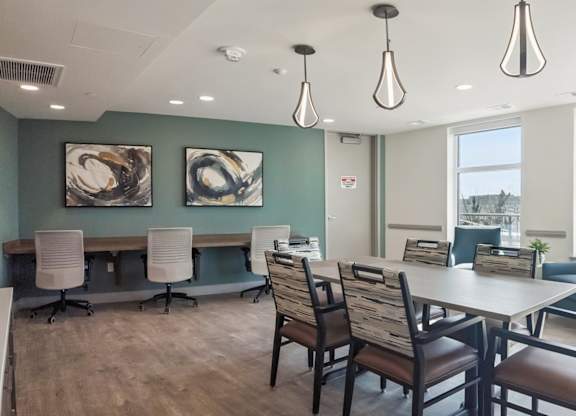 A room with a table and chairs and two paintings on the wall.