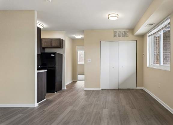 A spacious room with a white door and a black refrigerator.