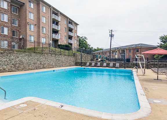 A swimming pool in front of apartment buildings.