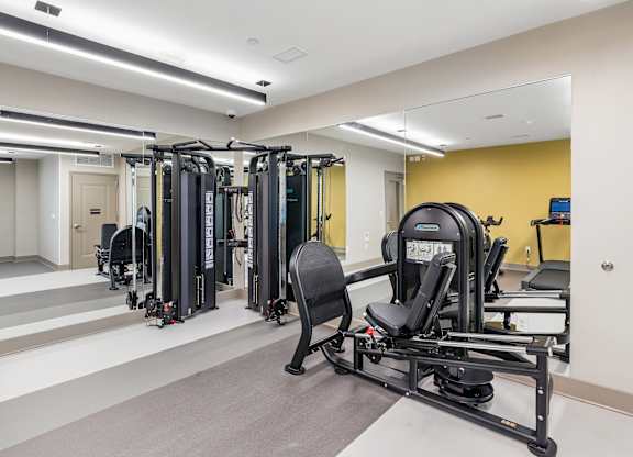 A gym with a variety of equipment including a rowing machine.