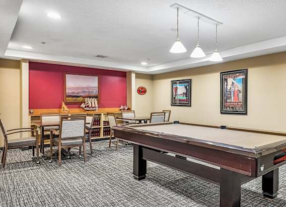 A room with a pool table and a dining table.