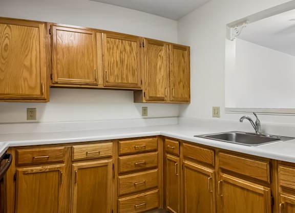 A kitchen with wooden cabinets and a white countertop.