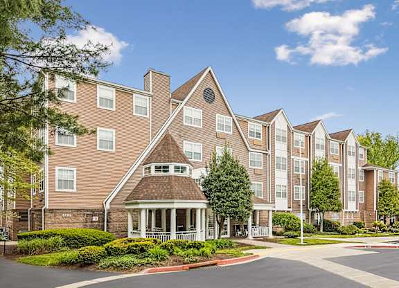 A large apartment complex with a central courtyard and a variety of trees.