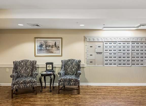 A waiting room with chairs and a painting on the wall.