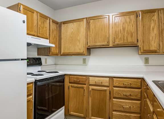 A kitchen with wooden cabinets and a white refrigerator.