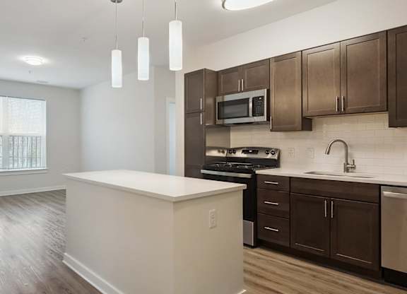 A kitchen with brown cabinets and a white island.