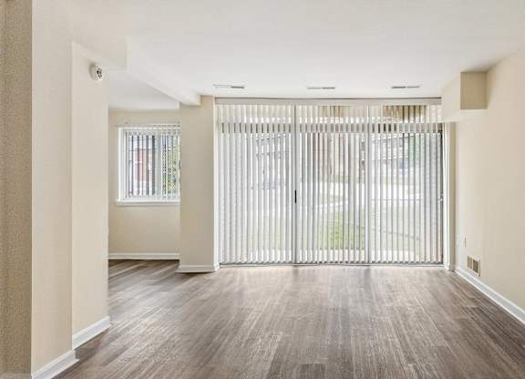 A room with a sliding door and wooden flooring.