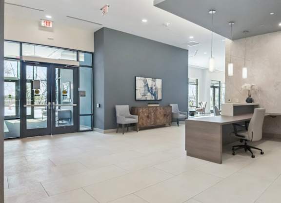 A modern office space with a reception desk and a chair.