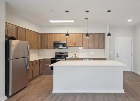 A modern kitchen with wooden cabinets and a white island.