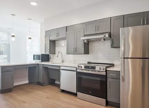 A modern kitchen with a stainless steel refrigerator, oven, and other appliances.
