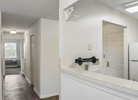 A white kitchen with a black handle on the counter.