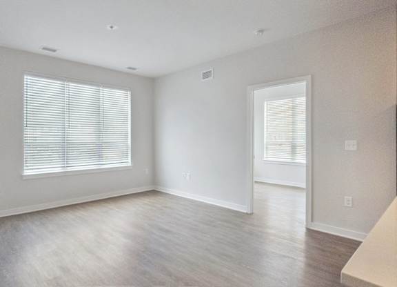 A spacious room with a window and a door.
