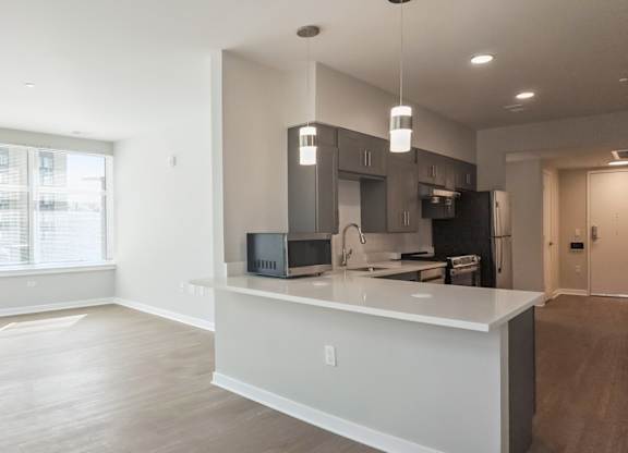 A modern kitchen with a large island and stainless steel appliances.