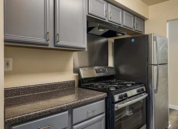 A kitchen with a black stove and refrigerator.