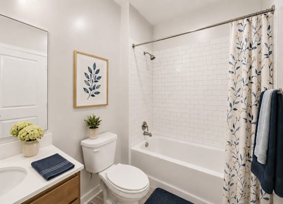 A white bathroom with a toilet, sink, and shower.