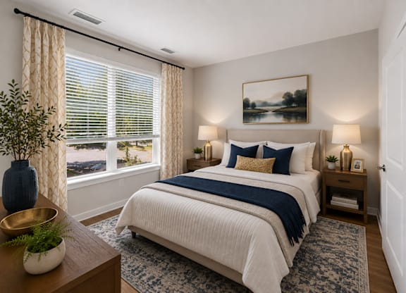 A bedroom with a large bed and a view of the outdoors through the window.