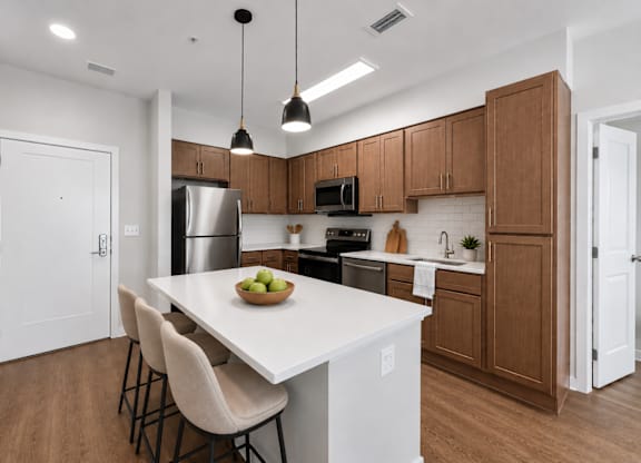 A kitchen with a white countertop and wooden cabinets.