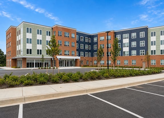 A large multi-story building with a parking lot in front.