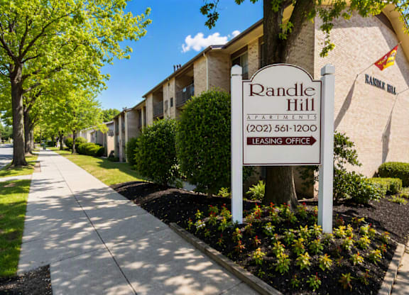 A sign for Randle Hill Apartments stands in front of apartment buildings.