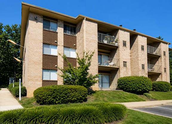 A large apartment building with a green lawn in front.