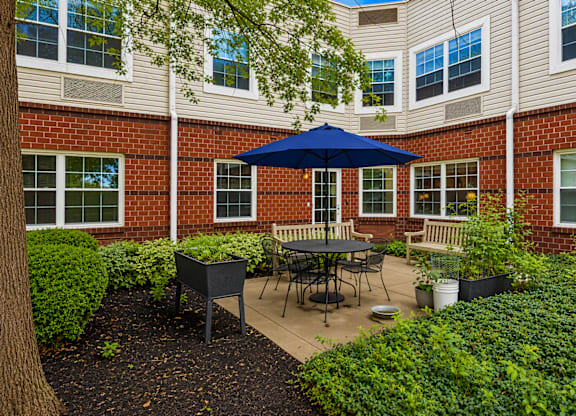 A patio with a table and chairs under an umbrella.