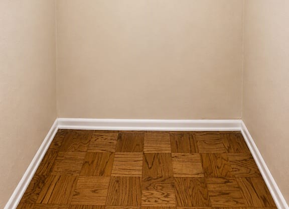 A room with two white shelves and a wooden floor.