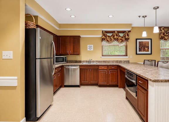 A kitchen with a refrigerator, sink, and cabinets.