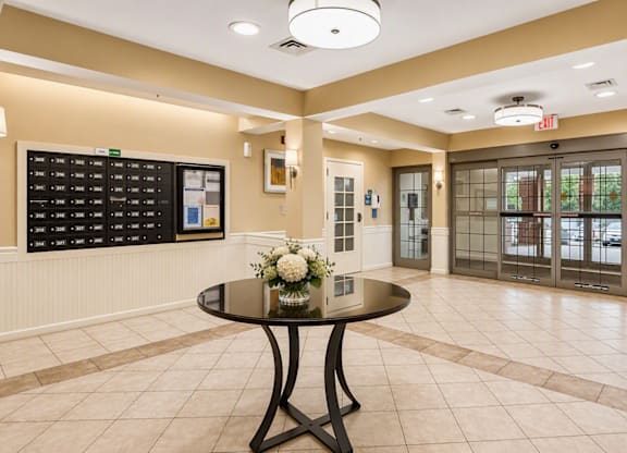 A black table with a vase of flowers on it in the middle of a room.