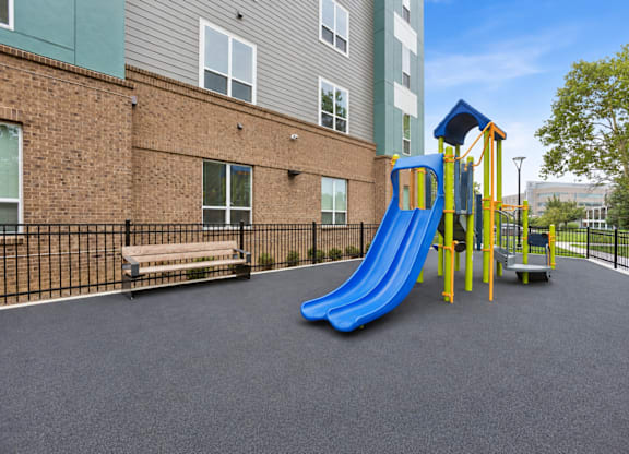 A playground with a blue slide and a yellow structure.