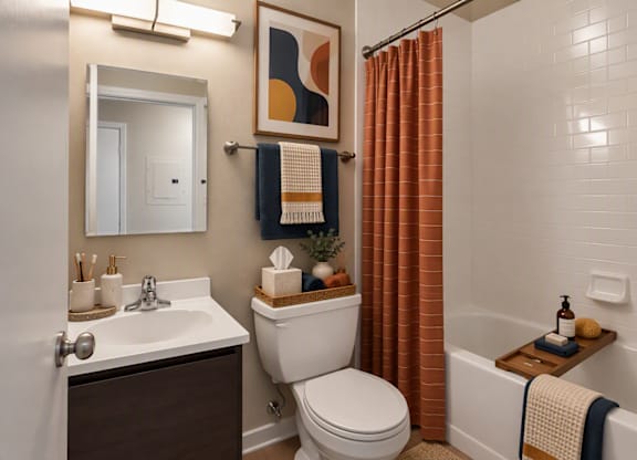 A bathroom with a toilet, sink, and shower.
